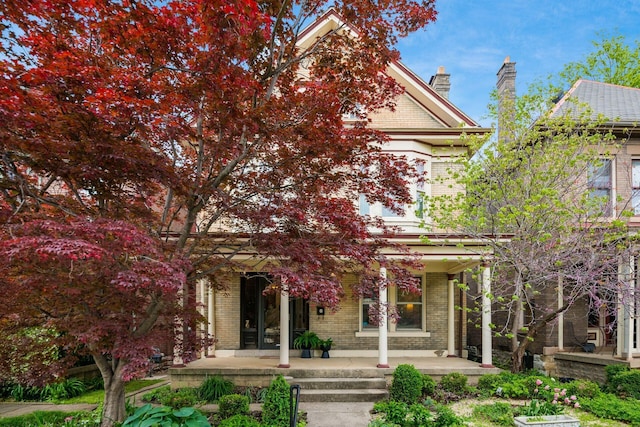 view of front of house featuring a porch and brick siding
