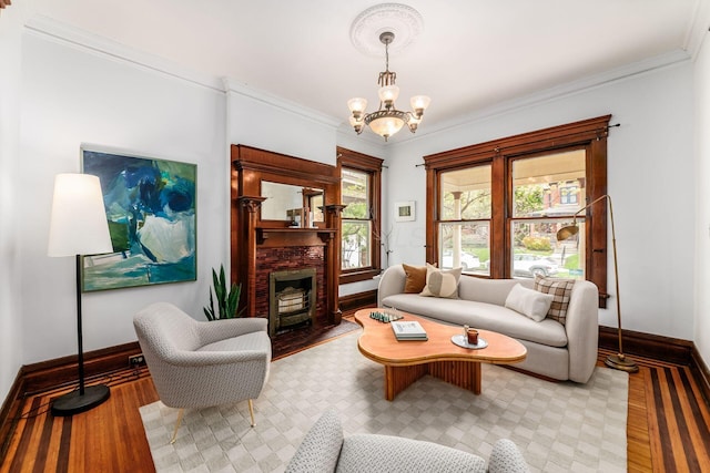 living area featuring baseboards, ornamental molding, light wood finished floors, and a notable chandelier