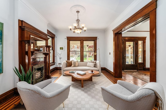 living room featuring baseboards, a high end fireplace, light wood finished floors, and a chandelier