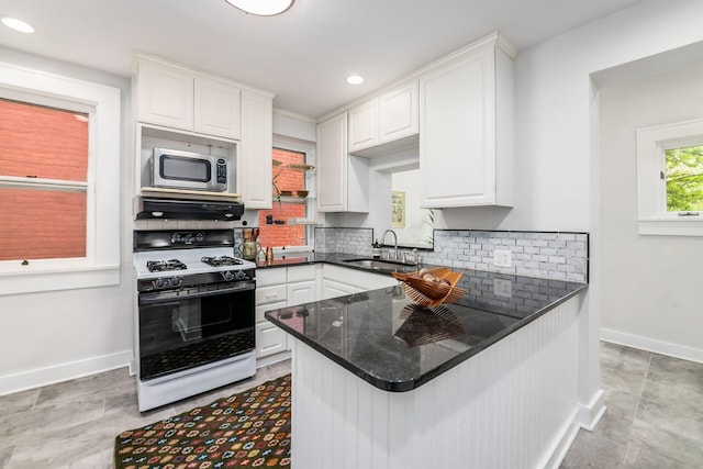 kitchen featuring a sink, white cabinets, stainless steel microwave, and gas stove
