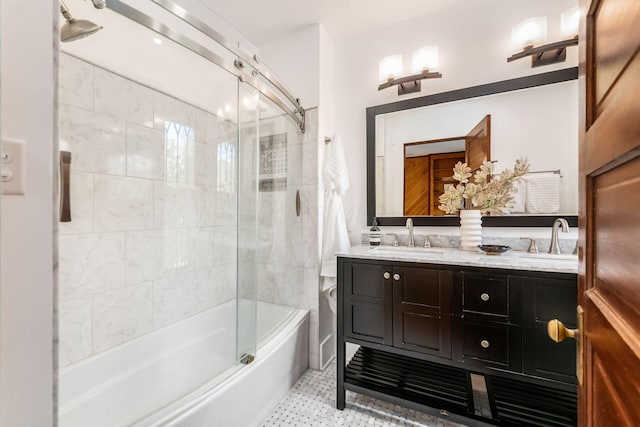 full bathroom featuring double vanity, tile patterned floors, combined bath / shower with glass door, and a sink