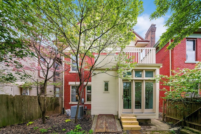 back of property featuring central AC, fence, and entry steps