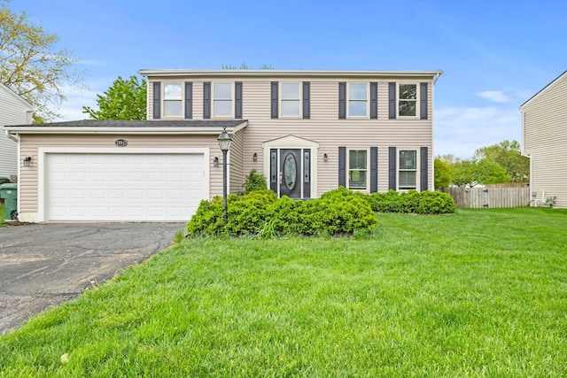 view of front of property featuring fence, a front lawn, and aphalt driveway
