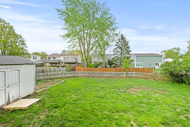 view of yard featuring a fenced backyard, an outbuilding, and a storage shed