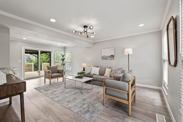 living room featuring crown molding, baseboards, visible vents, and light wood finished floors