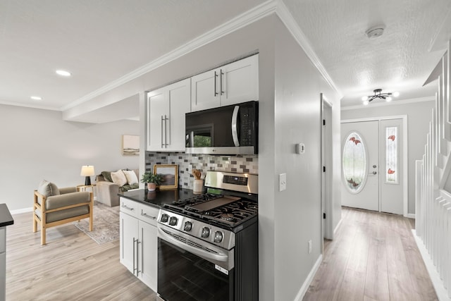 kitchen with baseboards, light wood-type flooring, white cabinets, tasteful backsplash, and stainless steel appliances