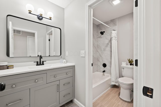 bathroom featuring visible vents, wood finished floors, vanity, toilet, and shower / bath combo with shower curtain