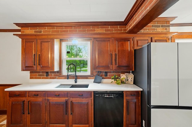 kitchen with freestanding refrigerator, black dishwasher, crown molding, and a sink