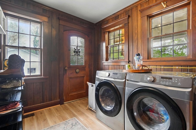 clothes washing area featuring washing machine and dryer, a healthy amount of sunlight, and laundry area