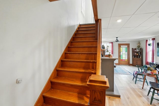 stairway with ceiling fan and wood finished floors