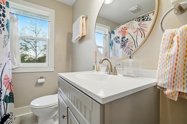 bathroom with vanity, toilet, baseboards, and wood finished floors