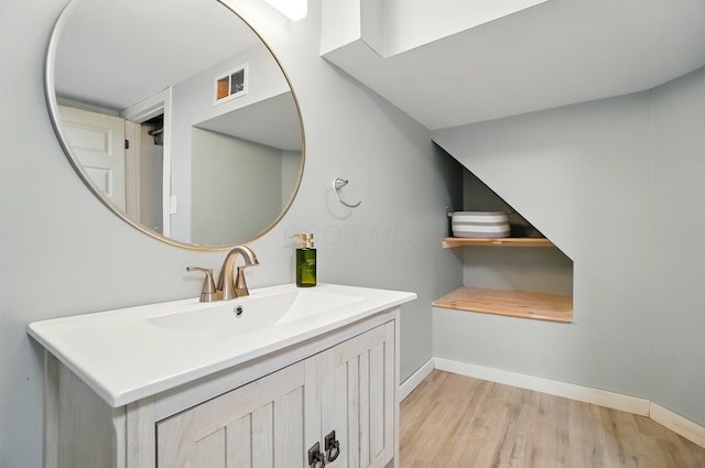 bathroom with vanity, baseboards, visible vents, and wood finished floors