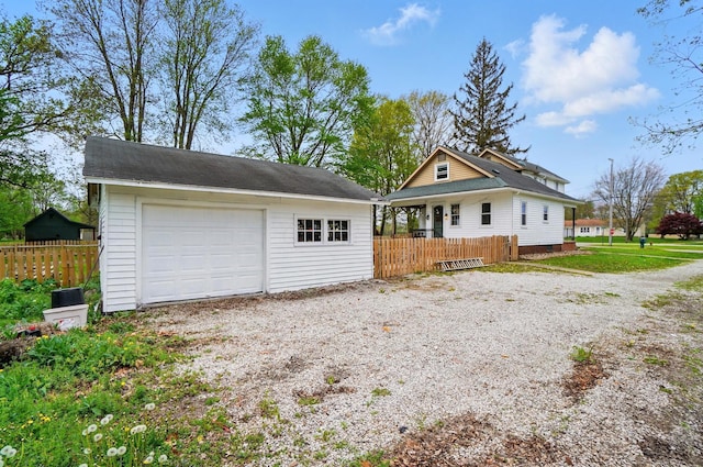 view of front facade with an outdoor structure, fence, and a detached garage