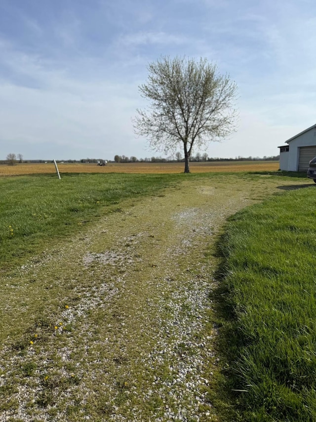 view of yard with a rural view and a garage