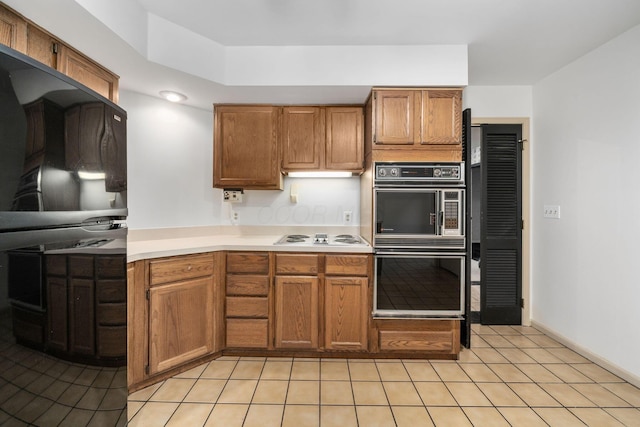 1624 Coppertree Ln, Columbus, OH 43232 - kitchen featuring light countertops, white electric stovetop, light tile patterned floors, and brown cabinets