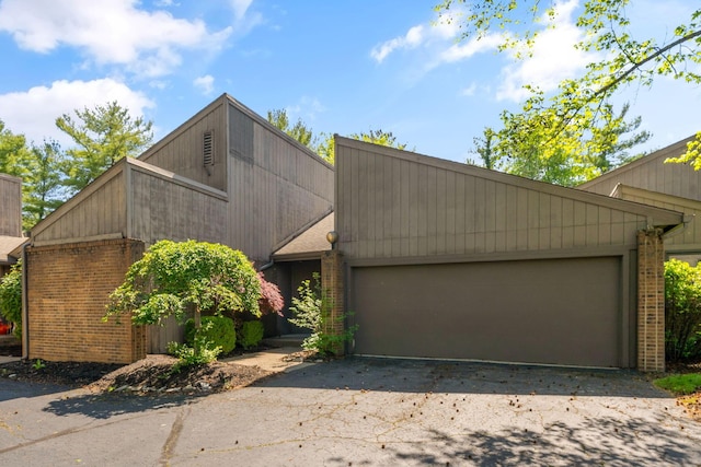 1624 Coppertree Ln, Columbus, OH 43232 - mid-century inspired home featuring a garage, brick siding, and asphalt driveway