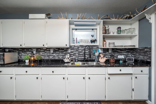 126 W S St, Hillsboro, OH 45133 - kitchen with a sink, stainless steel microwave, tasteful backsplash, white cabinets, and a textured ceiling