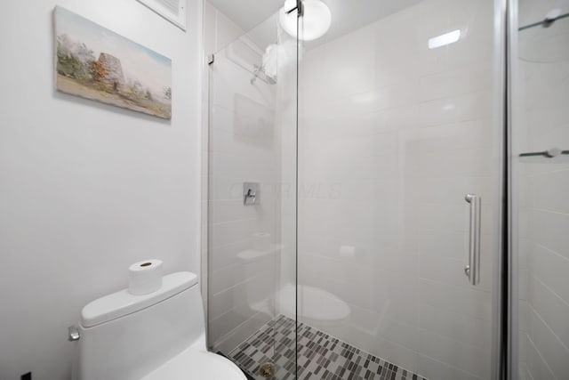 bathroom featuring toilet and a shower stall