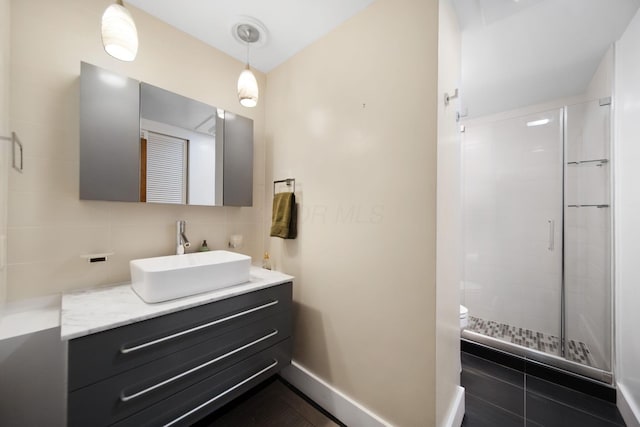 bathroom with vanity, toilet, tile patterned floors, backsplash, and a stall shower
