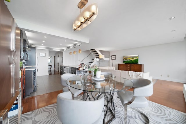 dining space featuring recessed lighting, stairs, and wood finished floors