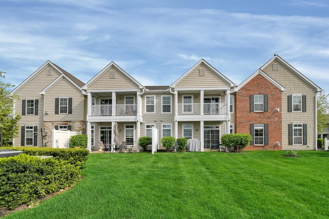 view of front facade with a balcony and a front lawn