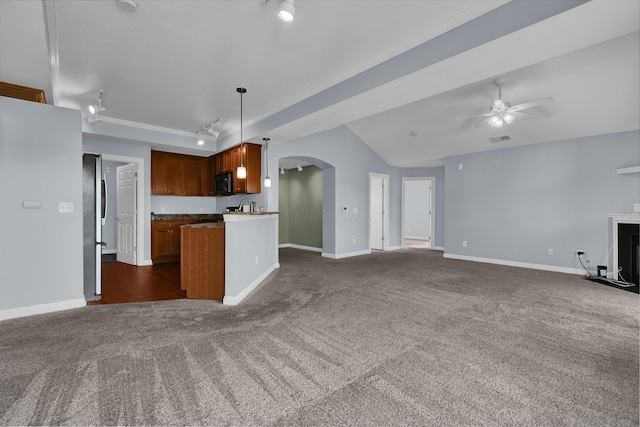 kitchen with a ceiling fan, arched walkways, track lighting, dark colored carpet, and open floor plan