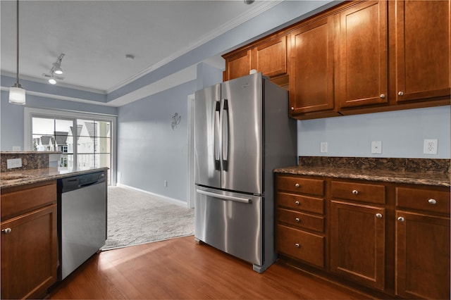 kitchen with dark wood-type flooring, ornamental molding, appliances with stainless steel finishes, and track lighting