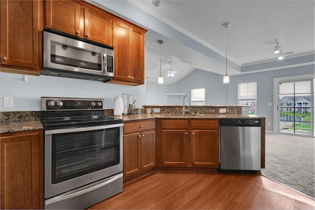 kitchen with a sink, stainless steel appliances, a ceiling fan, a peninsula, and light wood-type flooring