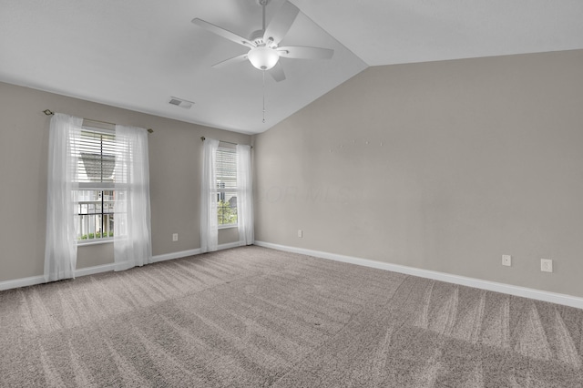 carpeted empty room featuring visible vents, baseboards, ceiling fan, and vaulted ceiling