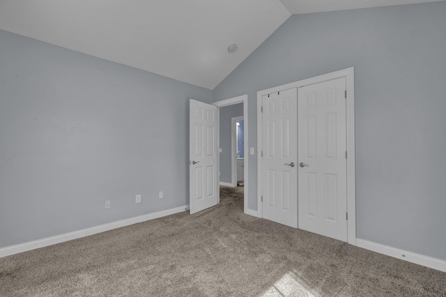 unfurnished bedroom with baseboards, carpet, lofted ceiling, and a closet