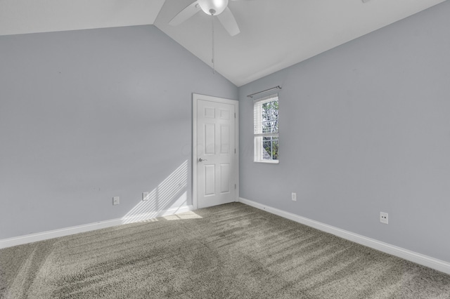 unfurnished room with ceiling fan, vaulted ceiling, baseboards, and carpet