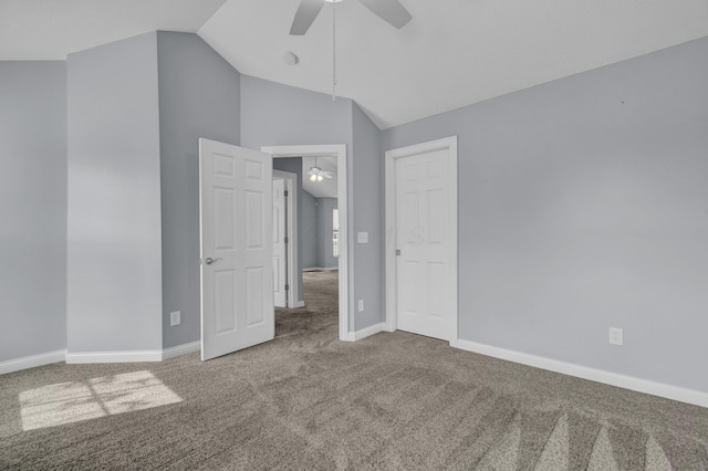 unfurnished bedroom with a closet, lofted ceiling, baseboards, a ceiling fan, and carpet