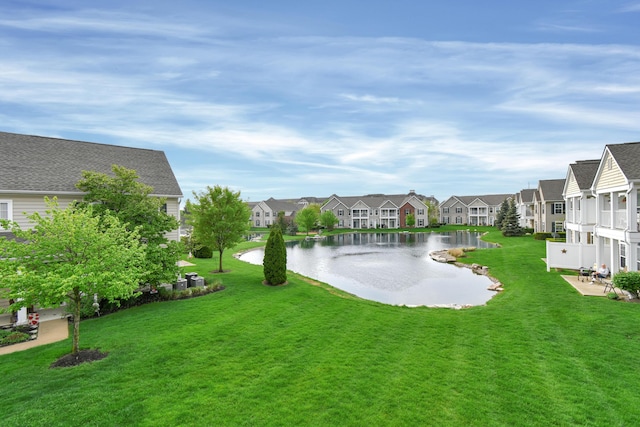 view of yard with a residential view and a water view