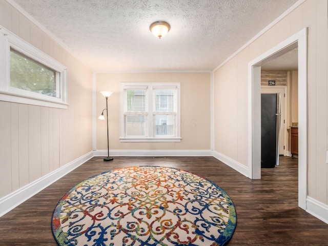 294 E Morrill Ave, Columbus, OH 43207 - empty room featuring healthy amount of natural light, ornamental molding, dark wood-type flooring, baseboards, and a textured ceiling
