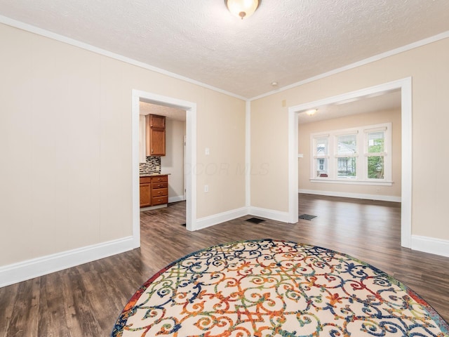294 E Morrill Ave, Columbus, OH 43207 - spare room featuring dark wood-style flooring, crown molding, a textured ceiling, and baseboards