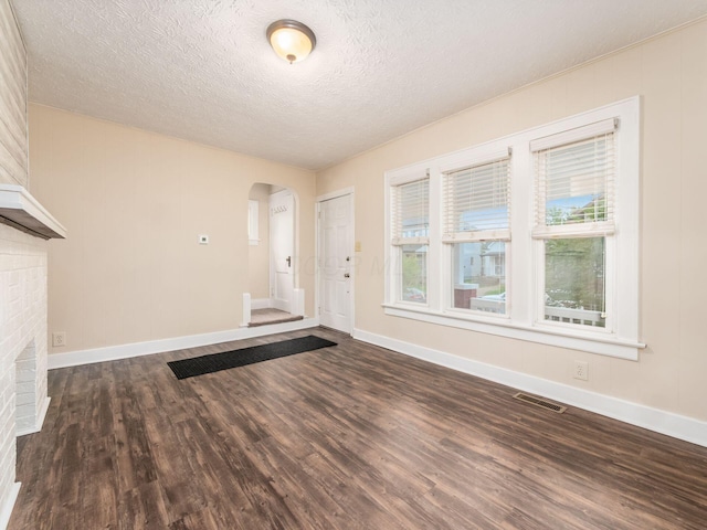 294 E Morrill Ave, Columbus, OH 43207 - foyer entrance with arched walkways, dark wood-style floors, baseboards, and a textured ceiling