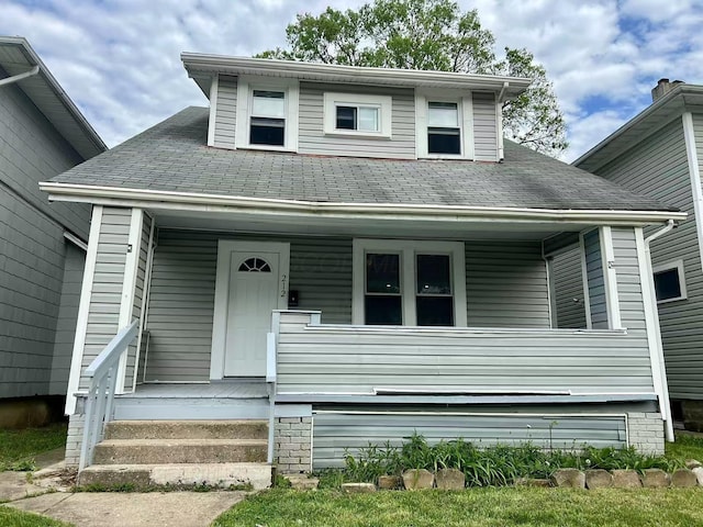 bungalow-style home featuring roof with shingles and covered porch