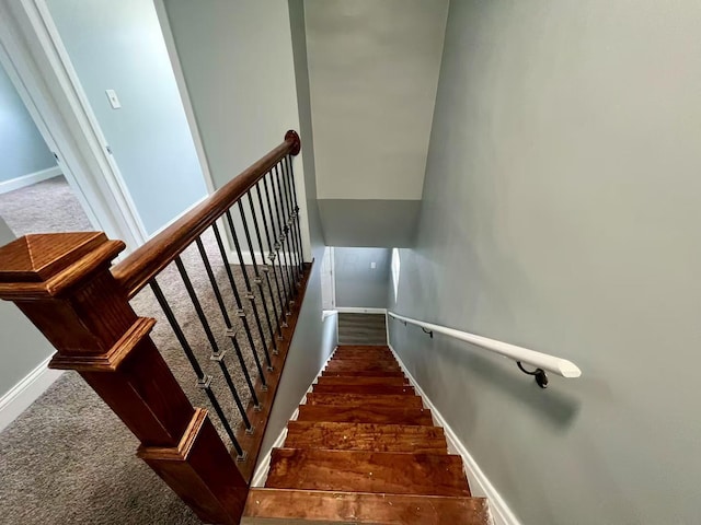staircase featuring baseboards and carpet floors