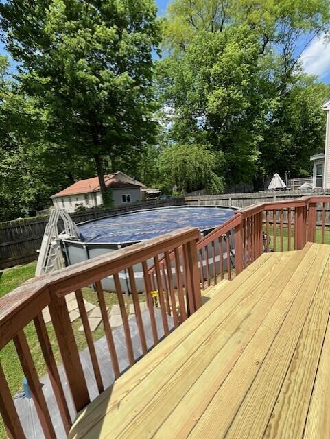 wooden deck with a fenced backyard and view of wooded area