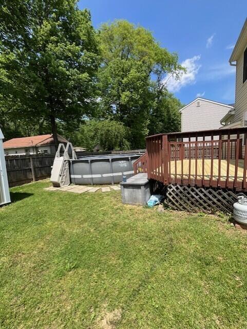 view of yard featuring an outdoor pool and a deck