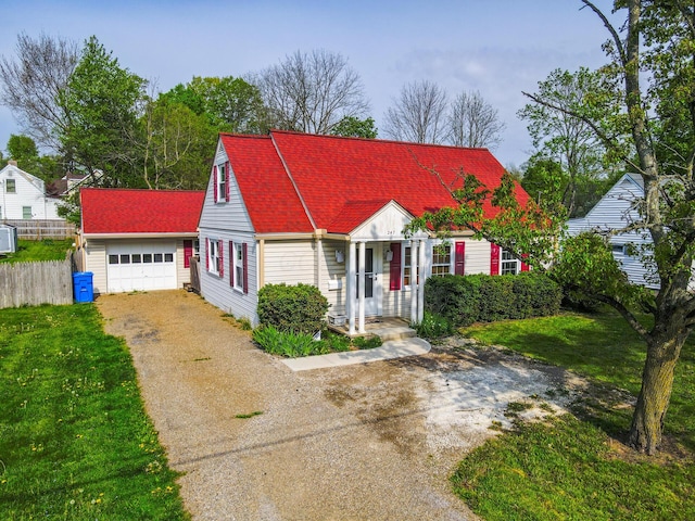 247 Bank St, Mount Gilead, OH 43338 - cape cod-style house featuring a garage, a front lawn, aphalt driveway, fence, and a shingled roof