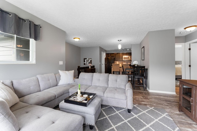 9137 Parkpoint Ln, Lewis Center, OH 43035 - living room with wood finished floors, baseboards, and a textured ceiling