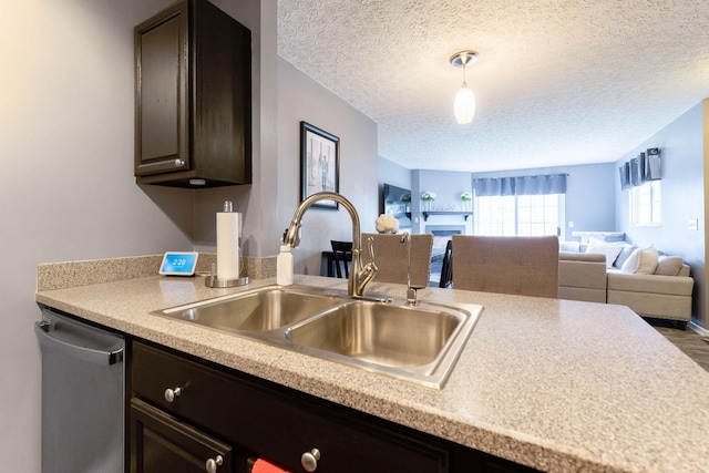 9137 Parkpoint Ln, Lewis Center, OH 43035 - kitchen with a sink, dishwasher, light countertops, a textured ceiling, and open floor plan