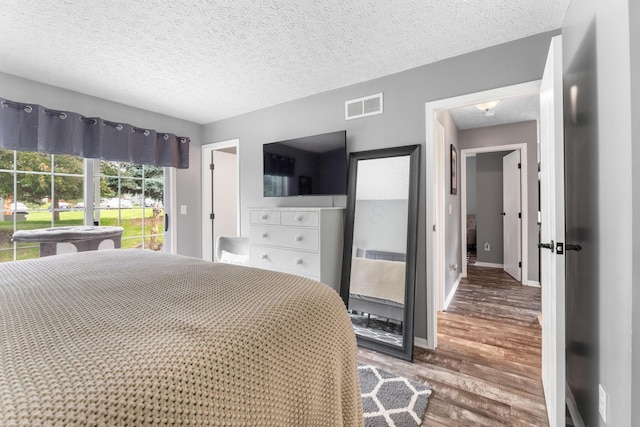 9137 Parkpoint Ln, Lewis Center, OH 43035 - bedroom featuring wood finished floors, a textured ceiling, and baseboards