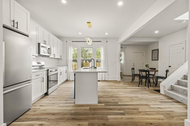 147 N Ogden Ave, Columbus, OH 43204 - kitchen featuring recessed lighting, light wood-style floors, white cabinets, and stainless steel appliances