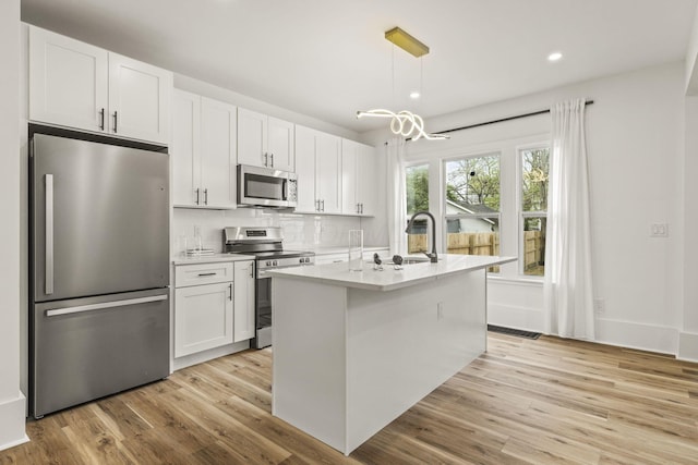 147 N Ogden Ave, Columbus, OH 43204 - kitchen featuring light countertops, appliances with stainless steel finishes, white cabinets, and light wood-style flooring