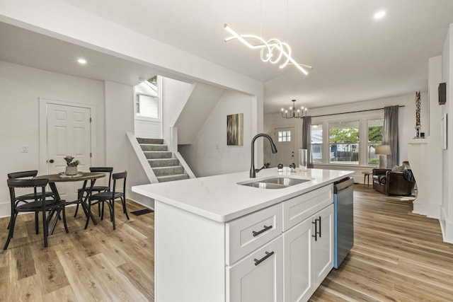 147 N Ogden Ave, Columbus, OH 43204 - kitchen featuring a notable chandelier, a sink, light wood finished floors, light countertops, and stainless steel dishwasher