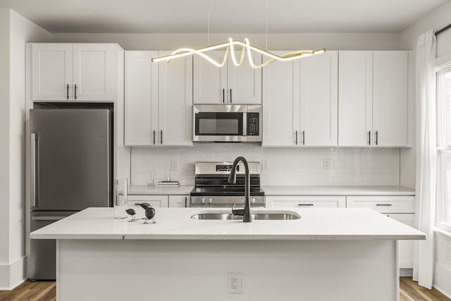 147 N Ogden Ave, Columbus, OH 43204 - kitchen with a sink, appliances with stainless steel finishes, decorative backsplash, and wood finished floors