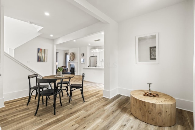 147 N Ogden Ave, Columbus, OH 43204 - dining room with baseboards, recessed lighting, light wood-style flooring, and a fireplace