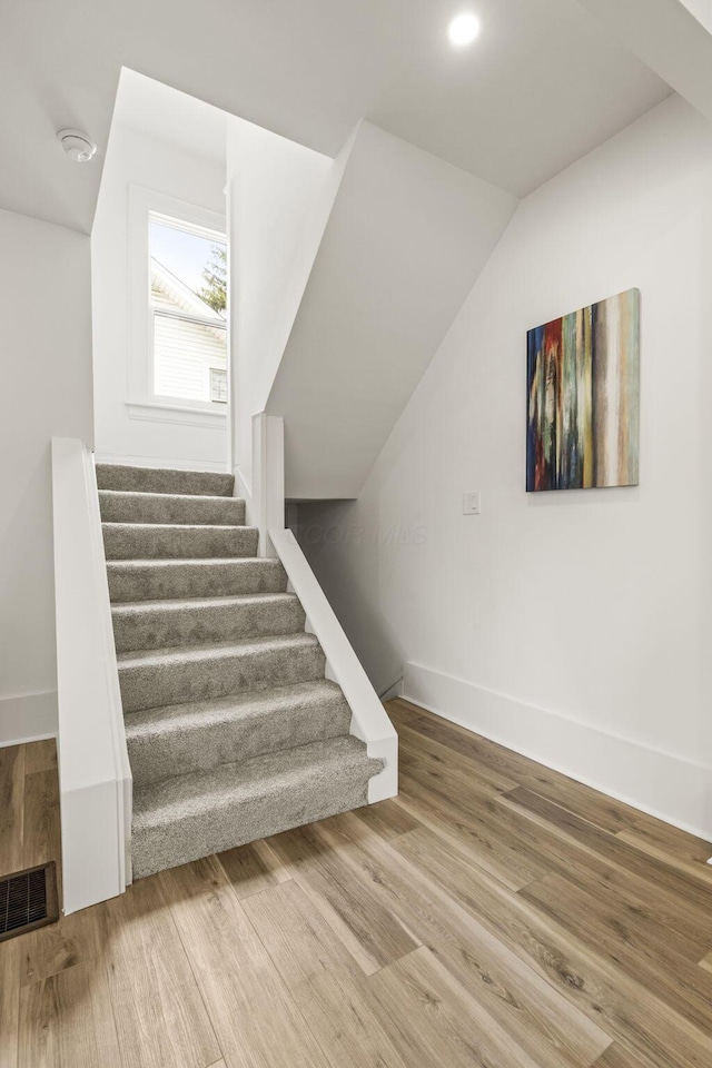 147 N Ogden Ave, Columbus, OH 43204 - stairs with baseboards, visible vents, wood finished floors, and vaulted ceiling